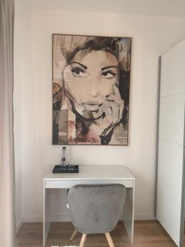a desk in a room with a painting on the wall at Sky Residence House in Cluj-Napoca