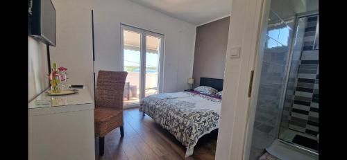 a bedroom with a bed and a desk and a window at Bed and breakfast Nika in Rab