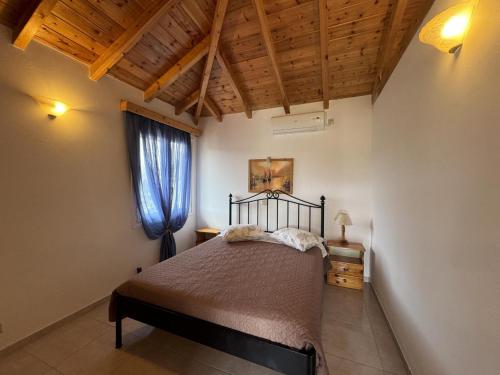 a bedroom with a bed and a window at Akrojali in Kómboi