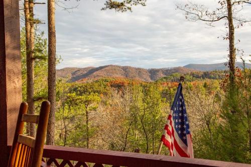 a flag on a porch with a view of the mountains at Living on the Ledge - Long-Range Mountain Views - Hot Tub and Fire Pit in Blue Ridge