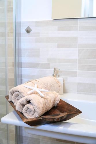 a towel sitting on top of a table next to a bath tub at Leukos Home Relais Ecoretreat b&b in Diamante