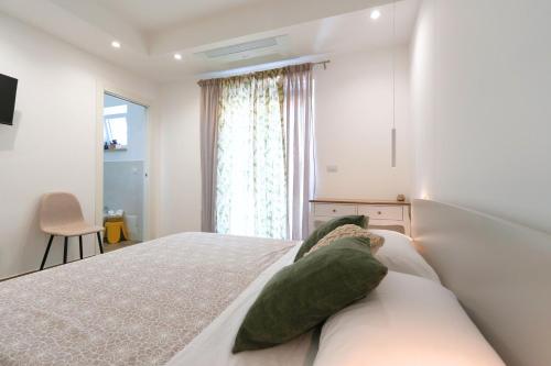 a bedroom with a bed with green pillows on it at Leukos Home Relais Ecoretreat b&b in Diamante