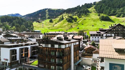 a city with a green hill in the background at Hotel Andino in Sankt Anton am Arlberg