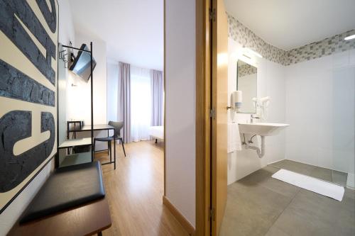 a bathroom with a sink and a table at Hotel Centro Vitoria AutoCheckIn in Vitoria-Gasteiz