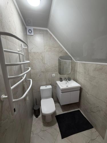a bathroom with a white toilet and a sink at Садиба Меланія in Svityazʼ