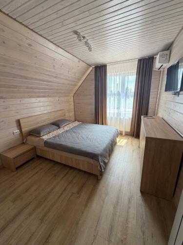 a bedroom with a bed in a wooden room at Садиба Меланія in Svityazʼ