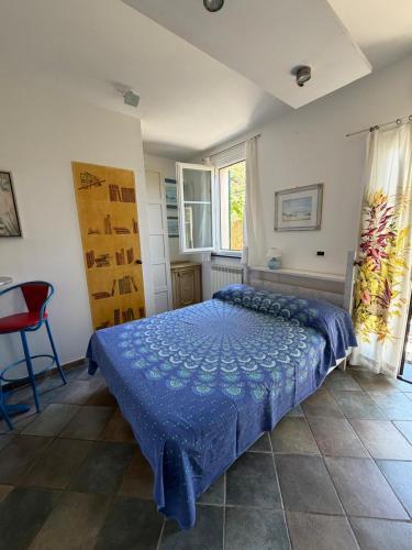 a bedroom with a bed with a blue comforter at B&B Al Bricco in Albisola Superiore