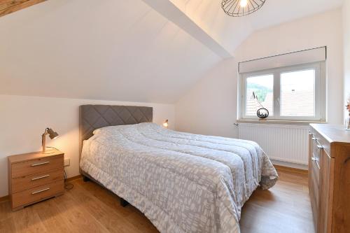 a white bedroom with a bed and a window at Printemps et Eté en Alsace in Stosswihr
