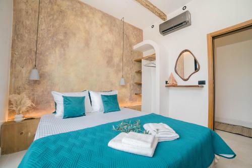 a bedroom with a blue bed with towels on it at Eden's Garden Villa in Ulcinj