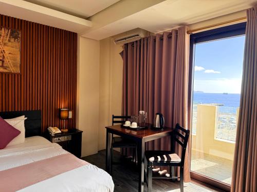 a hotel room with a bed and a desk and a window at Navarro Hotel in Caticlan