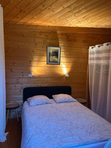 a bedroom with a bed in a wooden cabin at Chalet à Rhodes in Rhodes