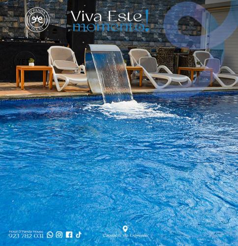 a fountain in a pool with chairs and a table at Hotel DPanda House in Luanda