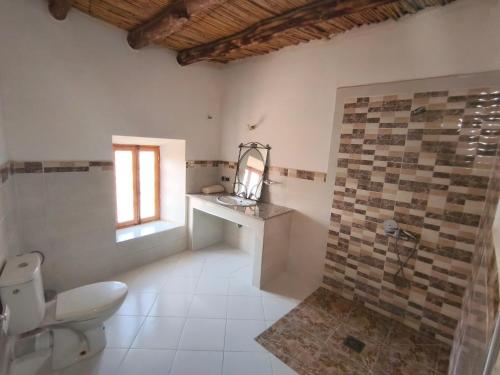 a bathroom with a toilet and a sink and a window at Riad tinghir in Tinerhir