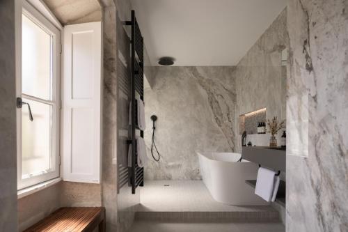 a bathroom with a white tub and a sink at Hotel des Quinconces Bordeaux Centre in Bordeaux