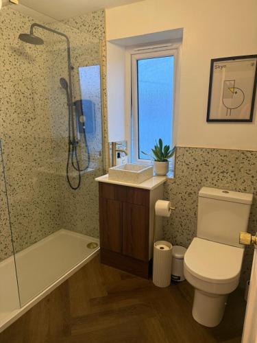 a bathroom with a toilet and a sink and a shower at This must be the place - Skye, Carbost in Carbost