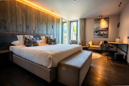 a large bedroom with a large bed and a desk at Hôtel Le Sanglier des Ardennes in Durbuy