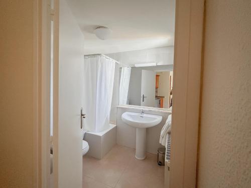a white bathroom with a sink and a toilet at Hostal Bertran in Salás de Pallás