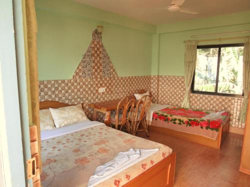 a bedroom with two beds and a table and chairs at Lake Vision Guesthouse in Pokhara