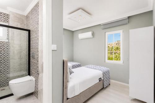 a white bathroom with a bed and a shower at Villa Delfin in Ortaca