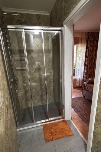 a shower with a glass door in a room at Hostel Anton in Tivat