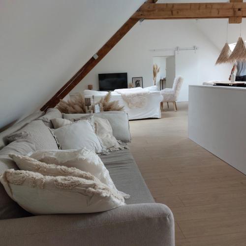 a living room with a couch with pillows on it at Le Grenier in Trois-Ponts