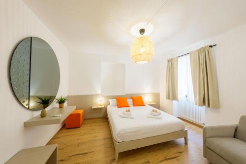 a bedroom with a bed and a mirror and a couch at Domio - Residenza del Corso in Atri