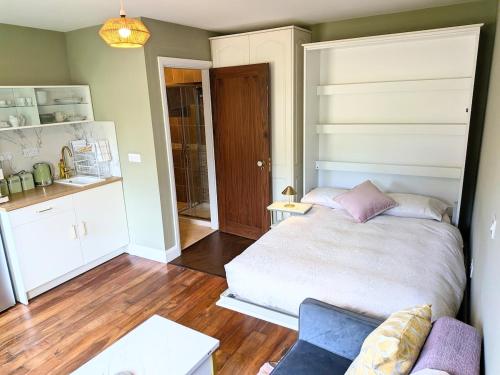 a small bedroom with a bed and a couch at Bolishka Whispers, Spacious Bright Studio accom in Galway