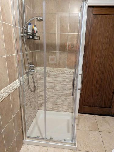 a shower with a glass door in a bathroom at Bolishka Whispers, Spacious Bright Studio accom in Galway