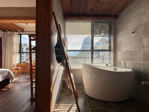 a bath tub in a bathroom with a window at Yangshuo Shui Mo Ju courtyard-Yangshuo Raiway St'ation free pick up for two nights in Yangshuo