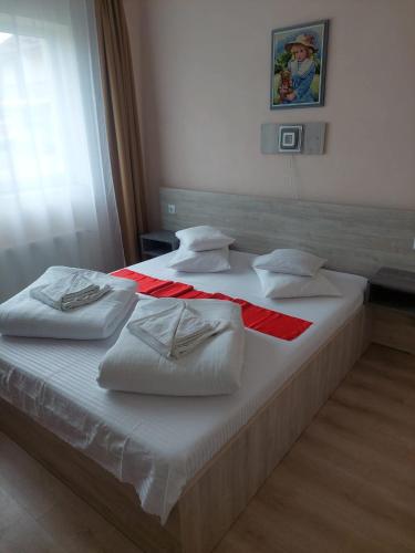 two beds with white sheets and pillows on them at Motel Biamin in Tăşnad