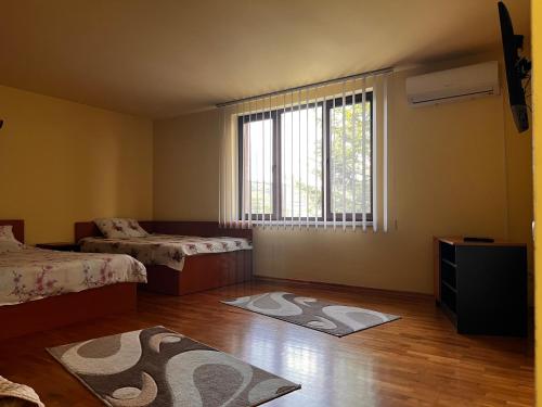 a bedroom with two beds and a large window at Vila Ovi Salin in Turda