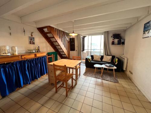 a living room with a table and a couch at T1 bis 200m du port in La Trinité-sur-Mer