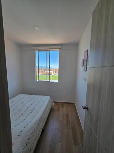 a small bedroom with a bed and a window at Apartamento cómodo completo y familiar in Ibagué