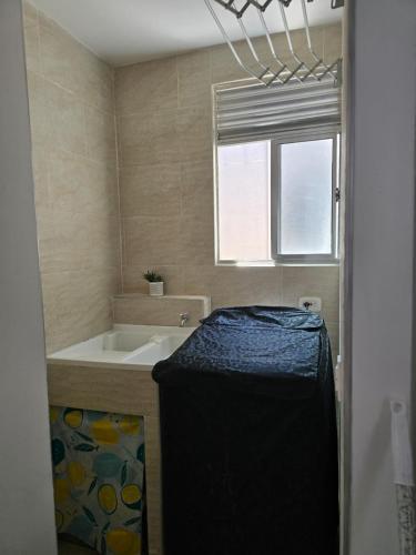 a bathroom with a tub and a sink and a window at Apartamento cómodo completo y familiar in Ibagué