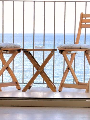 two chairs sitting on a balcony overlooking the ocean at The Six Ortigia Residences in Syracuse