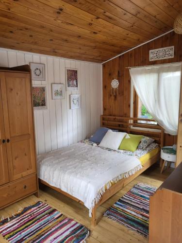a bedroom with a bed in a wooden room at Retro domki nad Wkrą in Kosewko