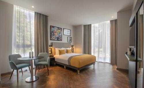 a hotel room with a bed and a table and chairs at Maldron Hotel Croke Park in Dublin
