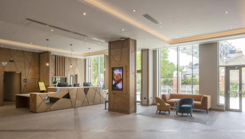 a lobby of a building with a desk and chairs at Maldron Hotel Croke Park in Dublin