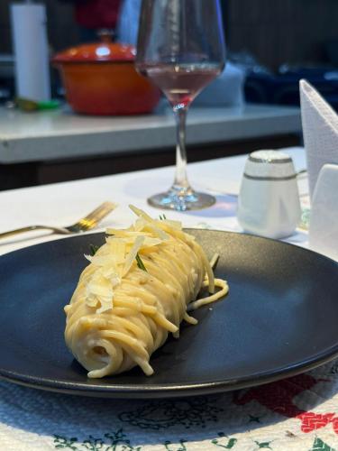 a plate of pasta on a table with a glass of wine at Soilsmart Haven in Abuja
