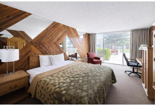 a bedroom with a bed and a desk and a window at Studio 6 Suites Rawlins WY in Rawlins