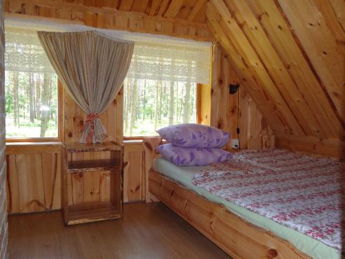 een slaapkamer met een bed in een blokhut bij Järve Cottages in Tehumardi