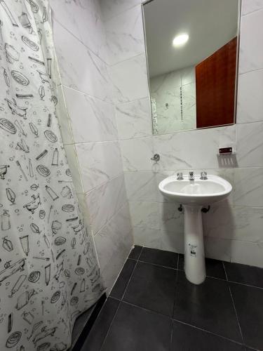 a bathroom with a sink and a shower curtain at Apartamentos La Posta in San Salvador de Jujuy