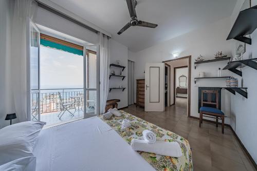 a bedroom with a large bed and a balcony at Classic Breeze - vista mare - terrazza - WiFi in Varazze