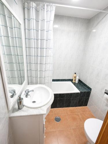 a bathroom with a sink and a bath tub at Apartamento Chicago in Mazagón