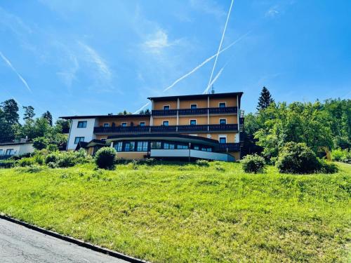 a building with a grassy field in front of it at Ferienpension Garni in Sankt Kanzian