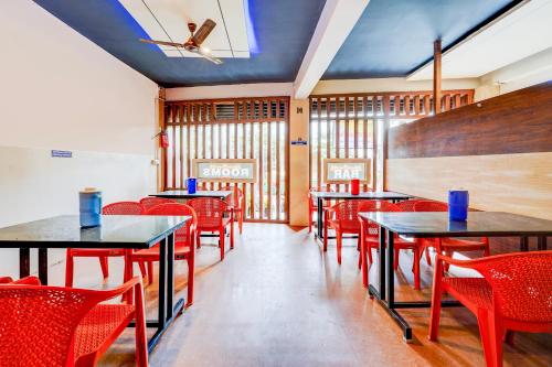 a dining room with tables and red chairs at Super HOTEL O UTSAV STAY in Jālahalli