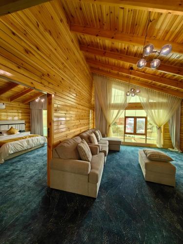 a living room with a couch and a bed at اكواخ لاكجري ابها in Abha