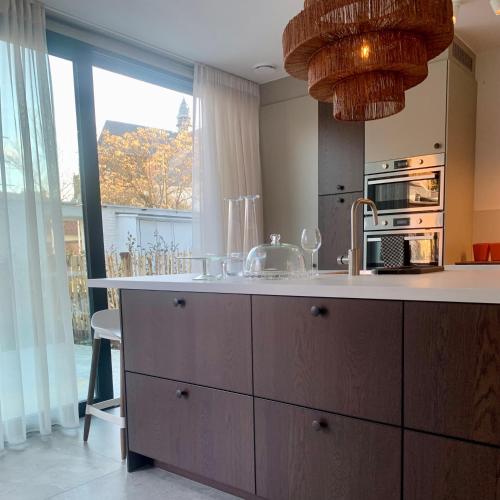 a kitchen with a sink and a large window at PATERSHOF vakantieverblijf in Diest