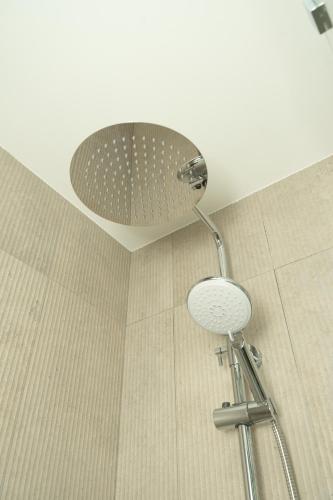 a shower with a shower head in a bathroom at Carvajal Street, Private rooms in Madrid
