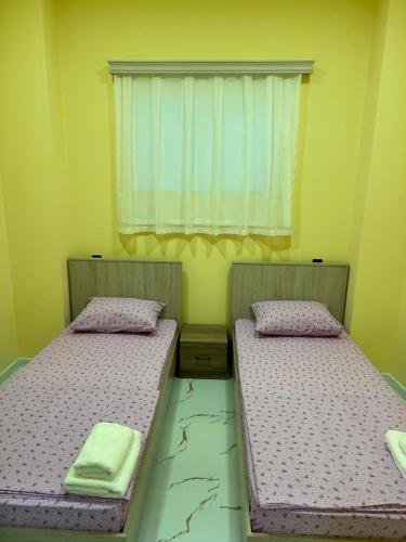 two twin beds in a room with a window at Eco Otel in Quba